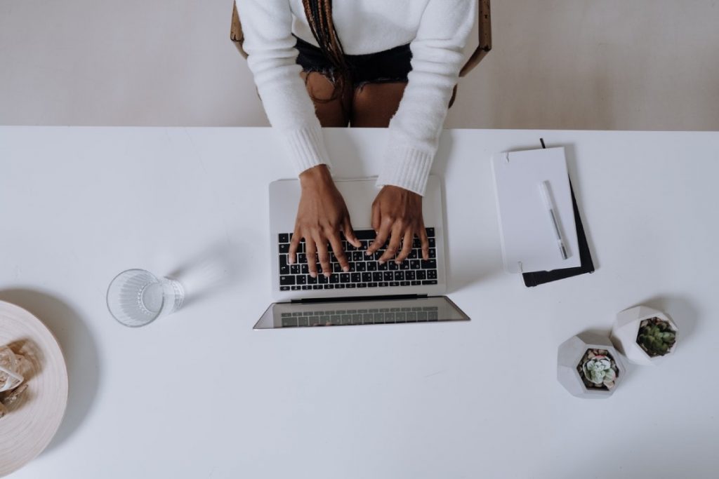 woman in white clothing typing